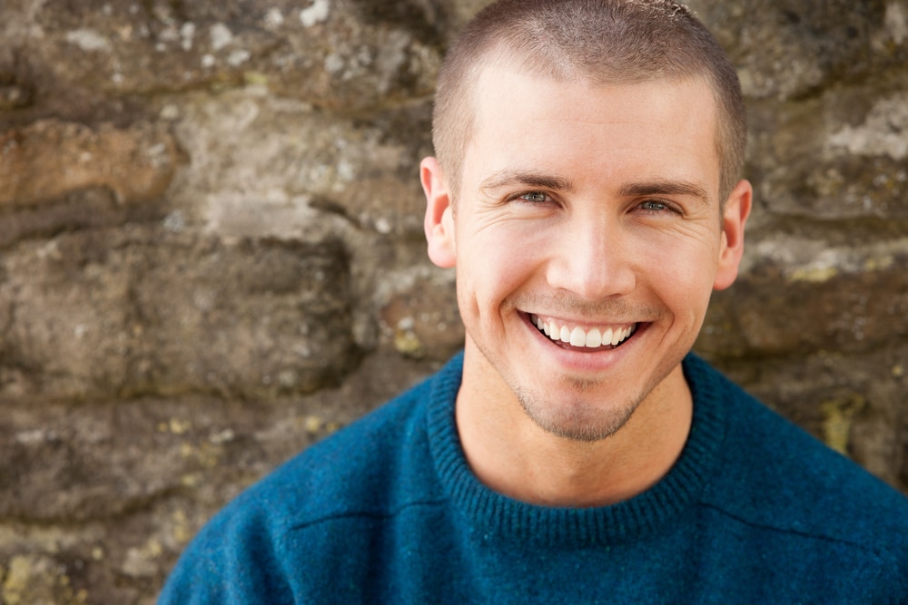 Attractive,Young,Man,Sitting,Outside.,He,Is,Smiling,At,The